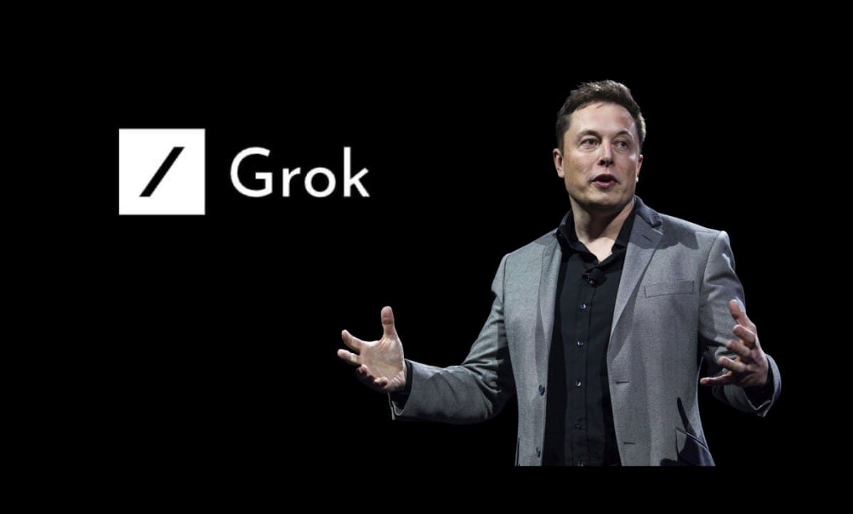 This image features Elon Musk standing in front of a black background with the "Grok" logo displayed beside him. The logo consists of a stylized slash (/) and the word "Grok" in a minimalist font. The image appears to be related to Musk's AI initiative under his company xAI, which developed "Grok," an AI chatbot integrated with X (formerly Twitter).